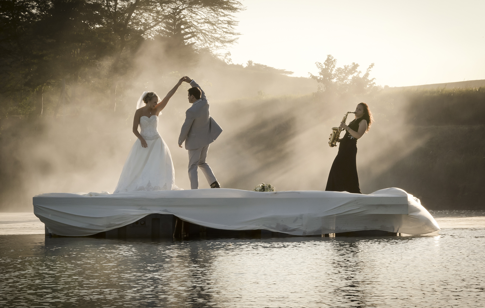 Bride and Groom dancing on a lake to music.