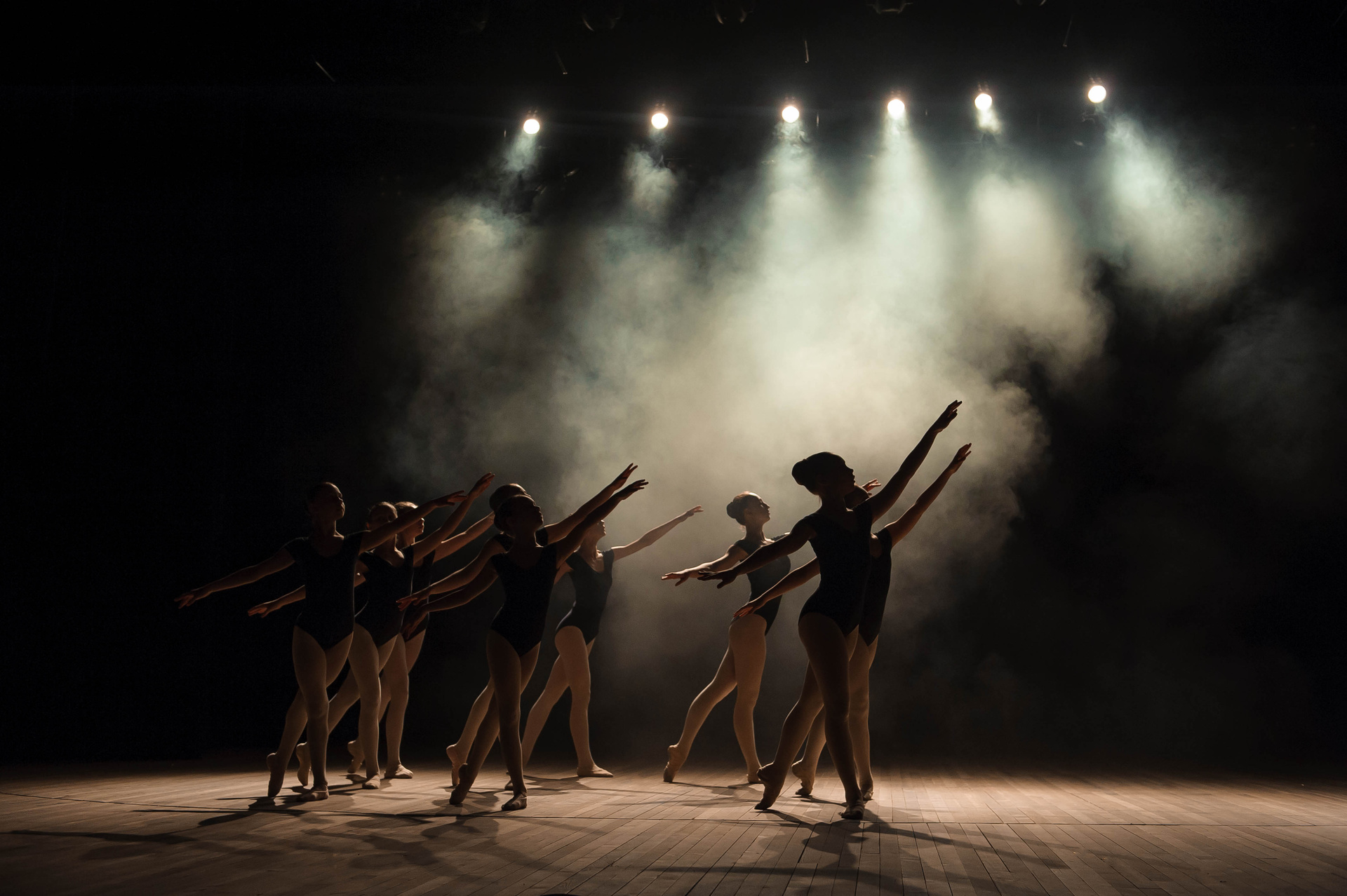 Ballet class on the stage of the theater with light and smoke. C